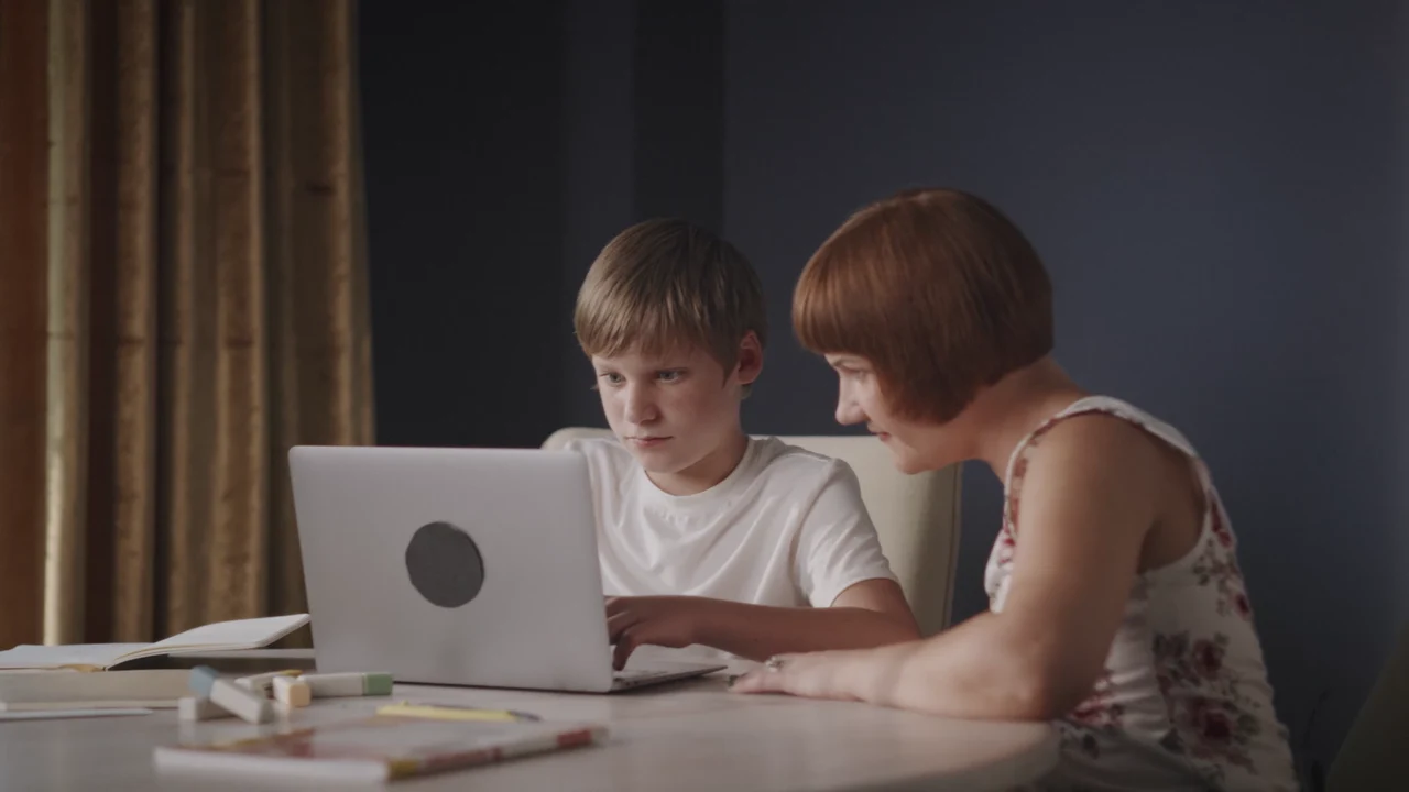 Silas and Kelly working together at a laptop